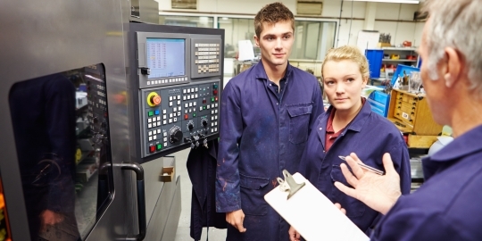 Twee studenten in de bouw overleggen met begeleider